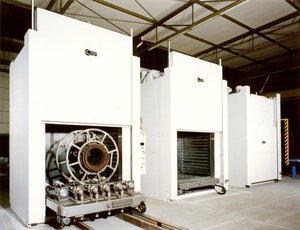 Indirect gas-fired chamber ovens with electrical lifting doors and automotive platform skids for manufacturing of large electric motors.